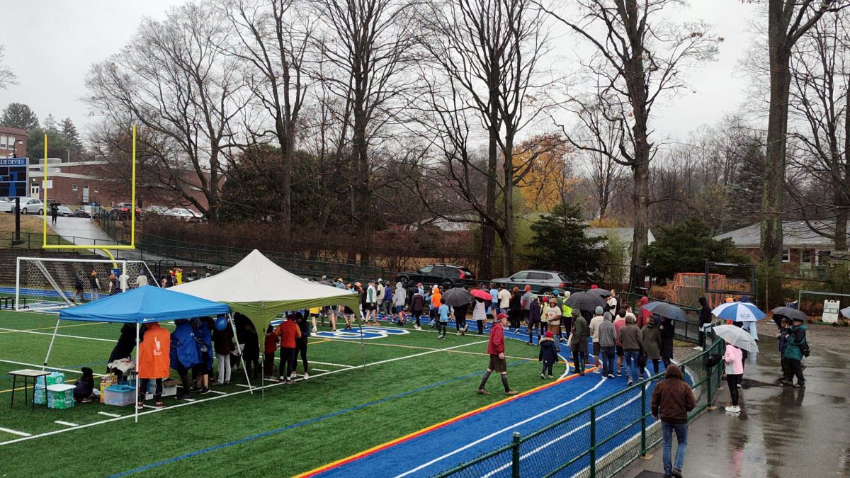 Amid a steady rain, community members gather at the Haldane turf on Thanksgiving morning to run the Turkey Trot.