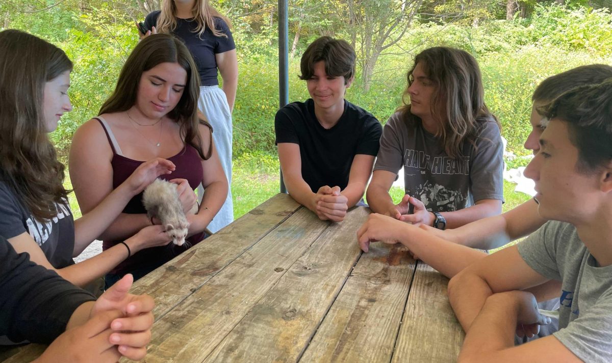 Juniors Delia Starr, Hudson Yeaple, Aaden Wik, Lachlan Koch, and Rhys Williams pass around a ferret during the junior trip to Camp Herrlich September 12, 2025.