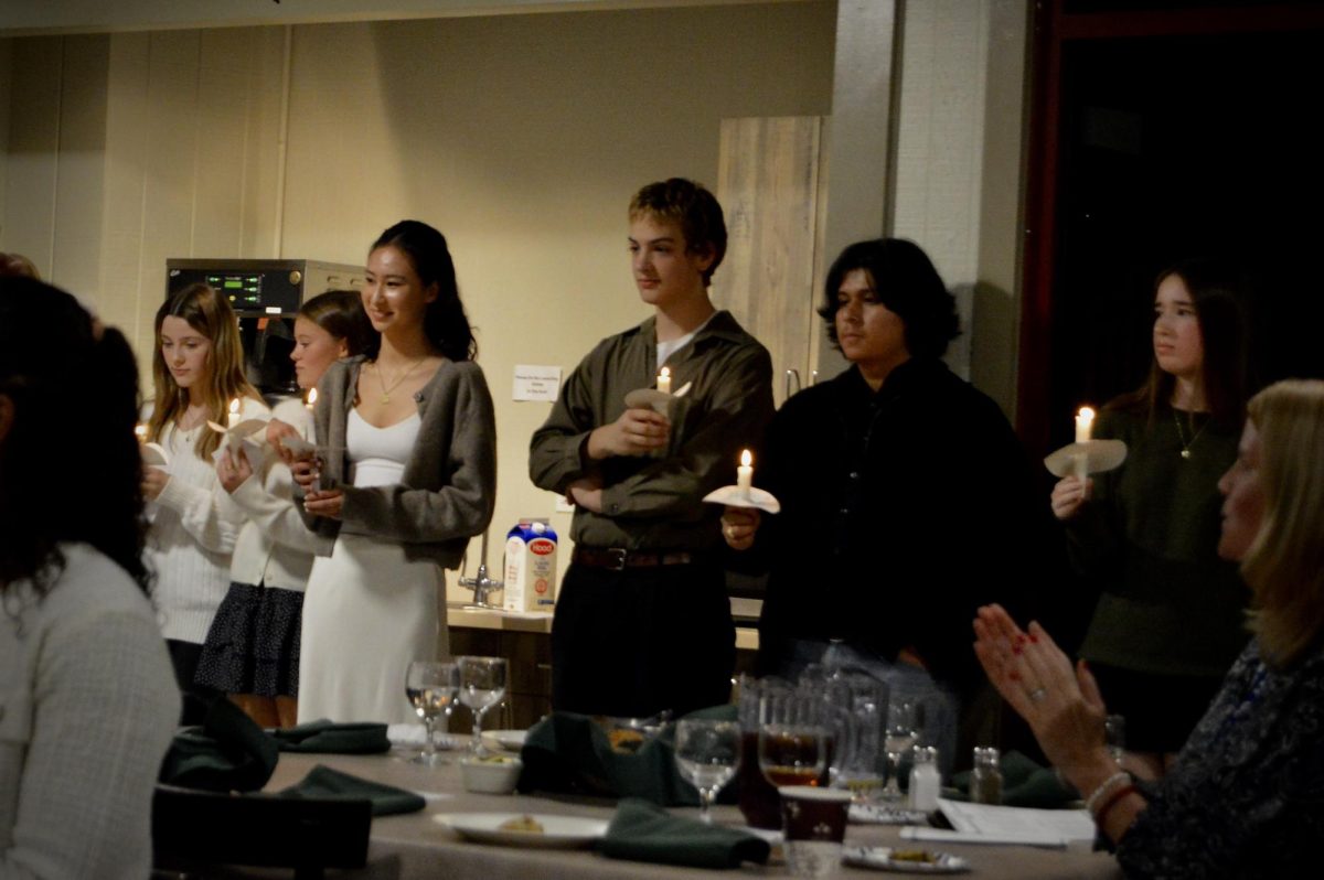 Juniors Lela Gurvich-Andrews, Stella Gretina, Clara Gelber, Henry Foley-Hedlund, Juan Fajardo, and Ryan Duncan hold candles after they deliver speeches during the induction ceremony for the National Honor Society at the Taconic Outdoor Center on Monday, November 24, 2025.
